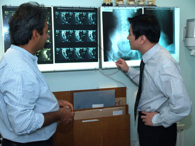 Dr Yoon Jeon examining a patient's X-ray results